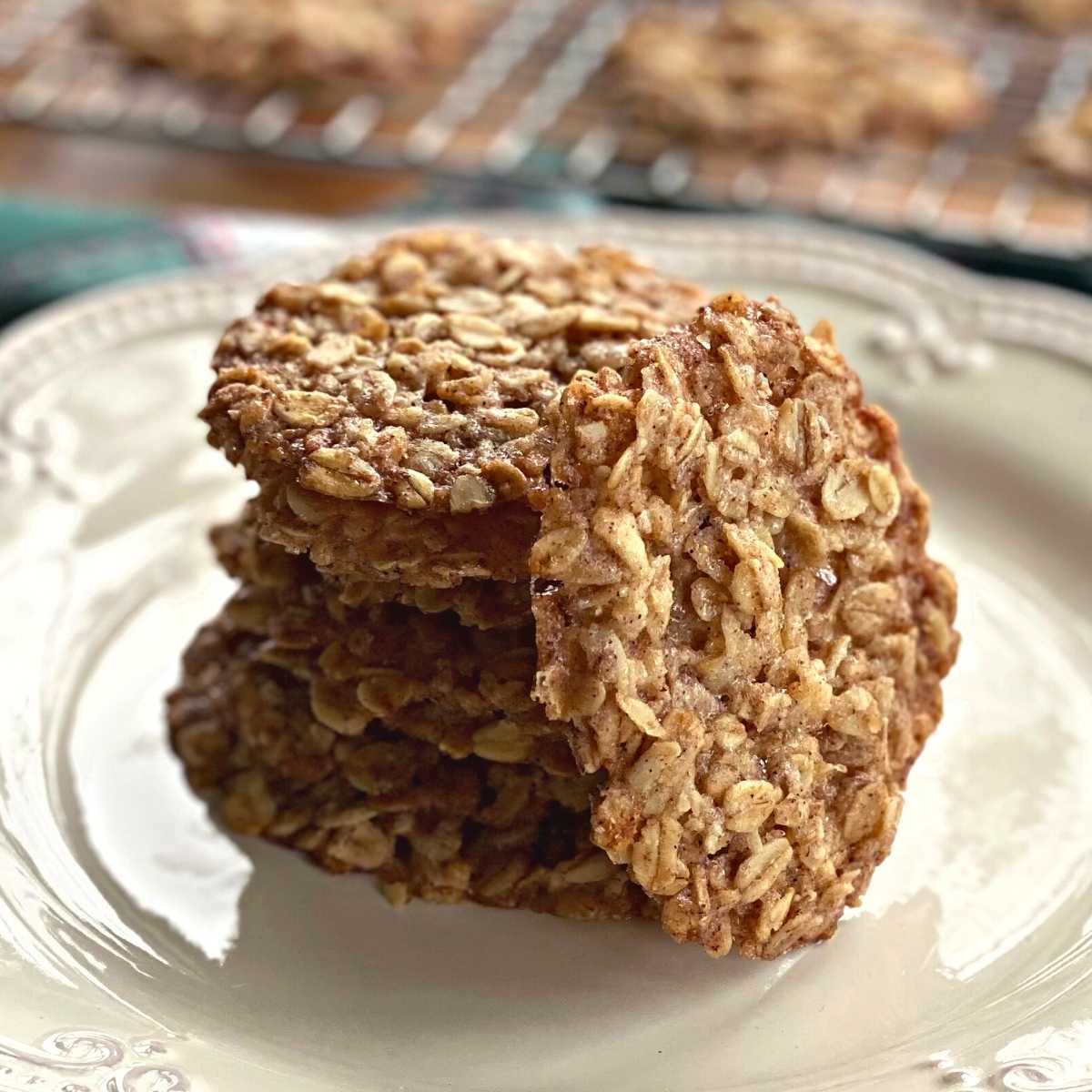 Vegan oatmeal lace cookies in a stack with one leaned against the stack.