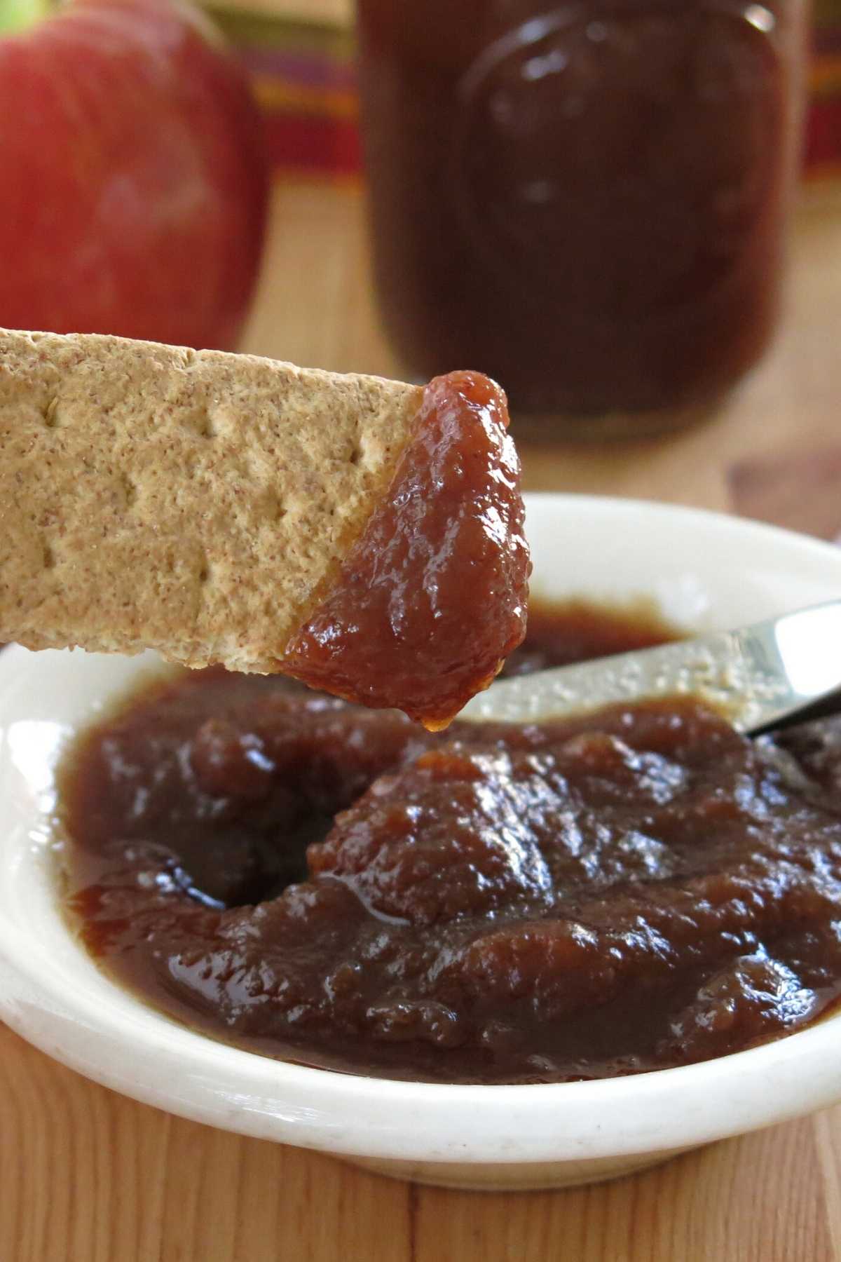 Healthy apple butter in a bowl and on a graham cracker.