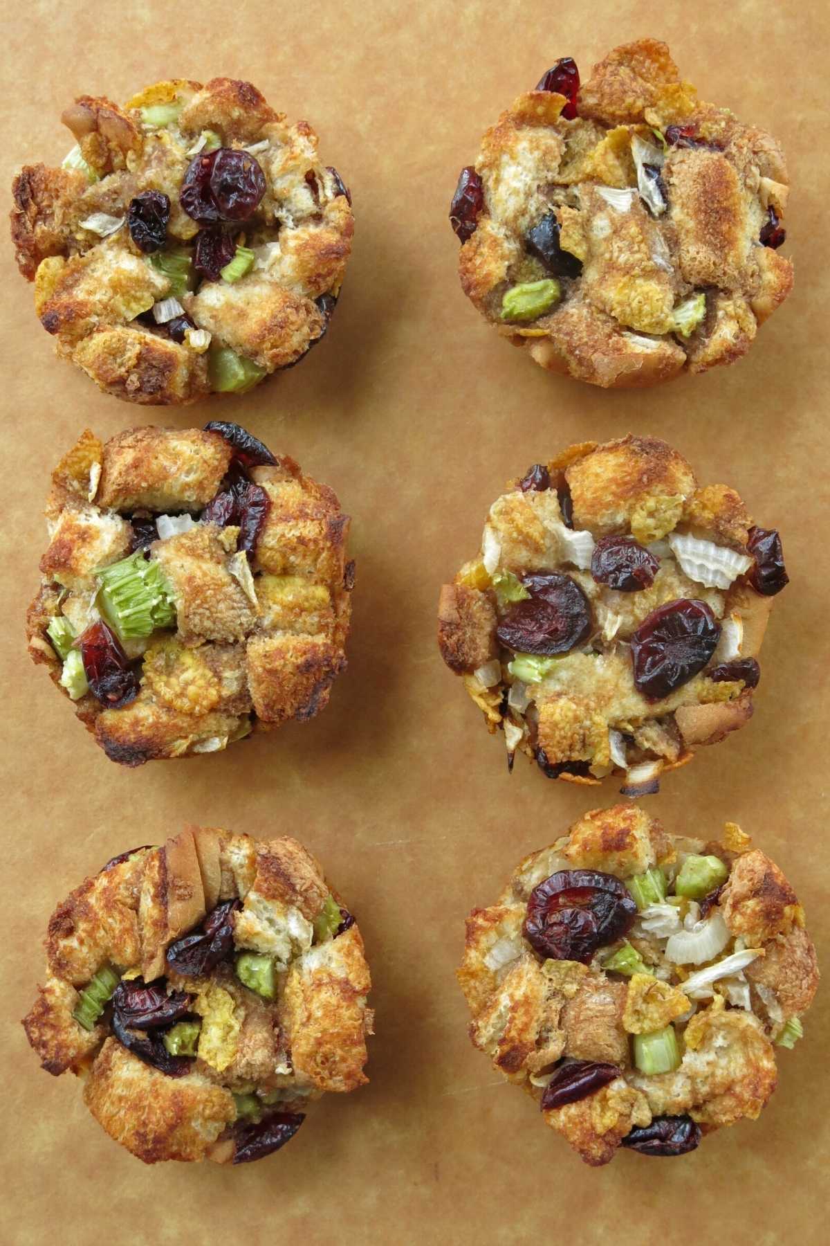 Stuffing muffins with cranberries on a serving board.