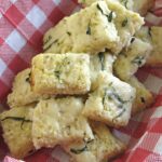 Cauliflower Pizza Bites in a basket lined with a red and white checkered napkin.