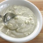 Easy blue cheese sauce for steak or burgers in a bowl with a spoon.