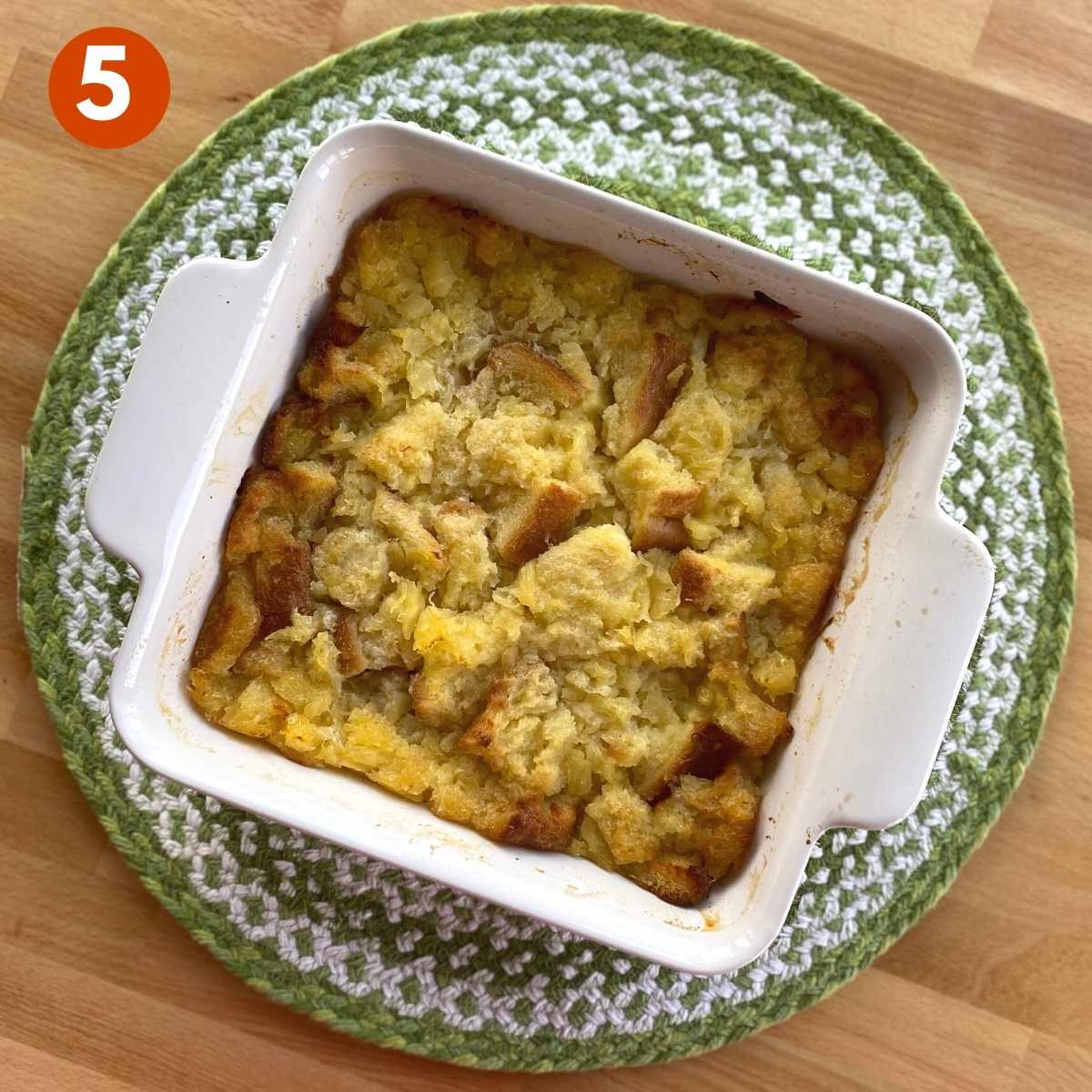 Cooked pineapple souffle casserole in a square baking dish.