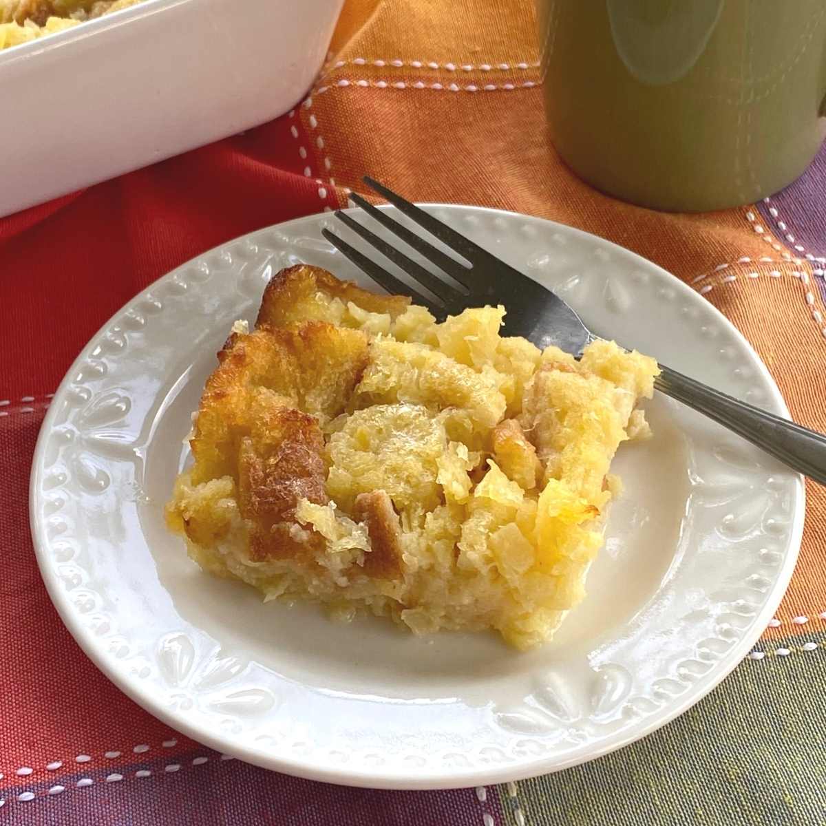 Serving of pineapple souffle on a plate with a fork.