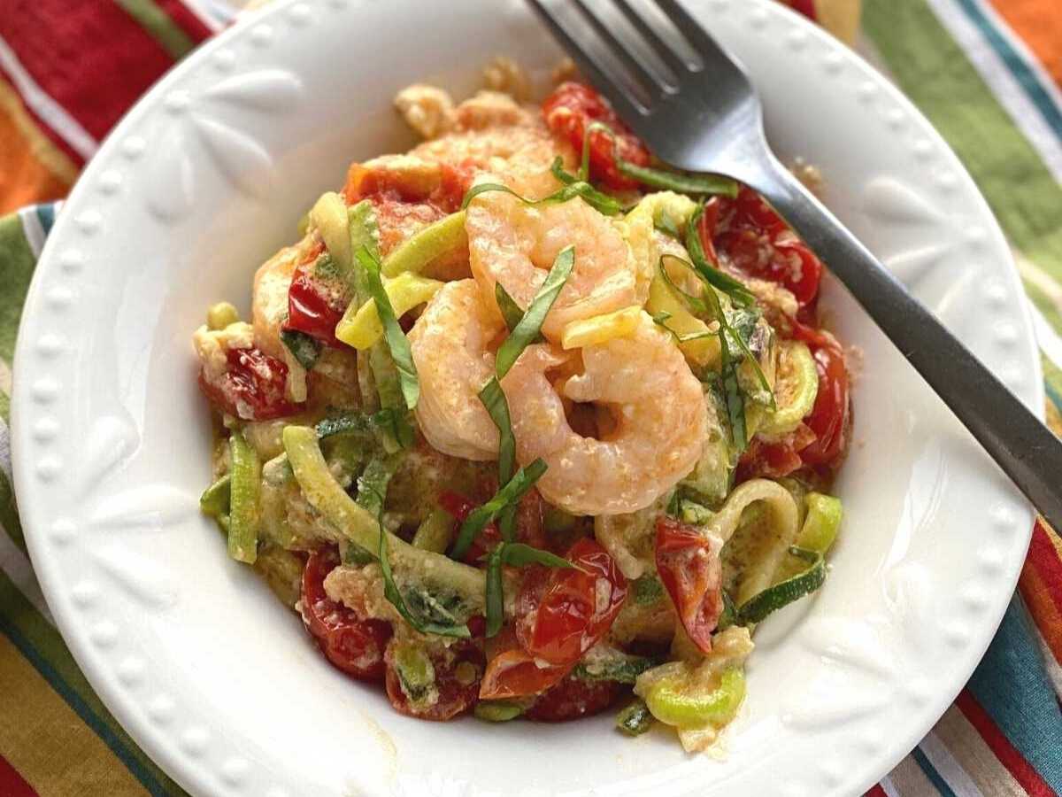 Low-carb feta pasta zoodles with shrimp in a white bowl with a fork.