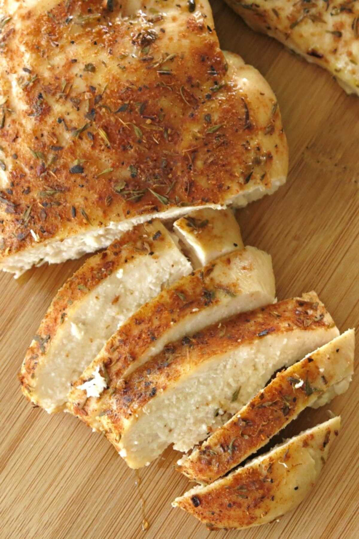 Oven-baked blackened chicken sliced on a cutting board.