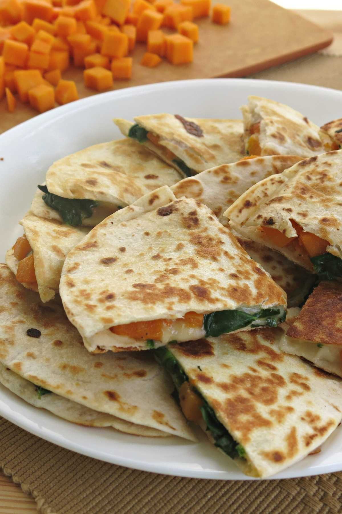 A plate of quesadillas made with butternut squash, spinach, and cheese.