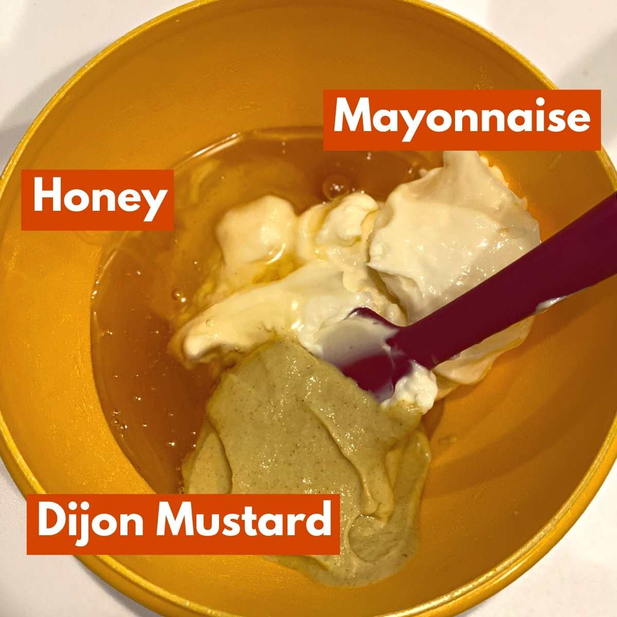 Honey mustard ingredients in bowl: Mayonnaise, Dijon mustard, honey.