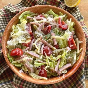 Columbia 1905 Salad with ham, cheese, green olives, and tomatoes and garlic vinaigrette dressing in a bowl.