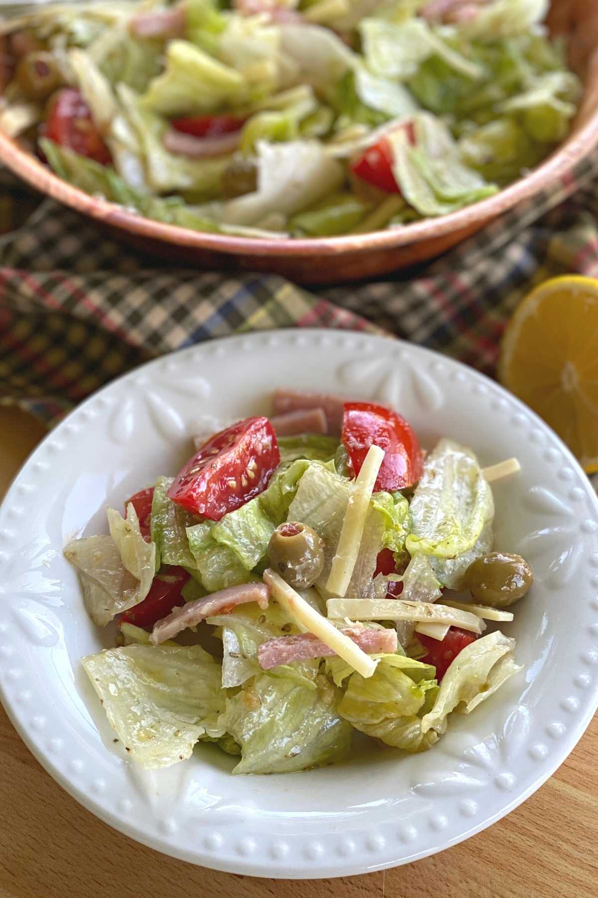 Side serving of Copycat 1905 salad on a small plate with larger bowl behind.