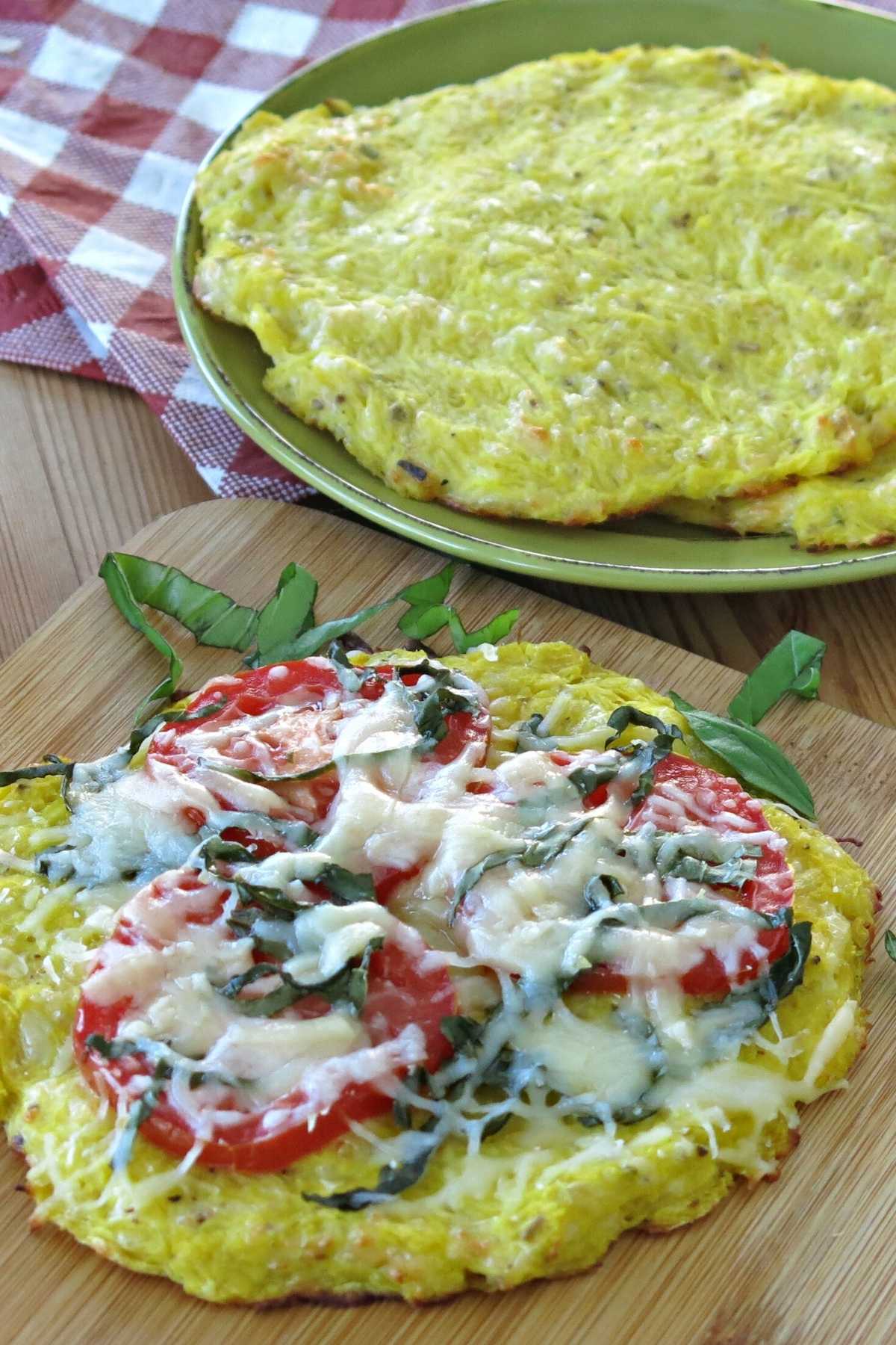 Crispy spaghetti squash pizza crust topped with tomatoes, basil, and mozzarella cheese.