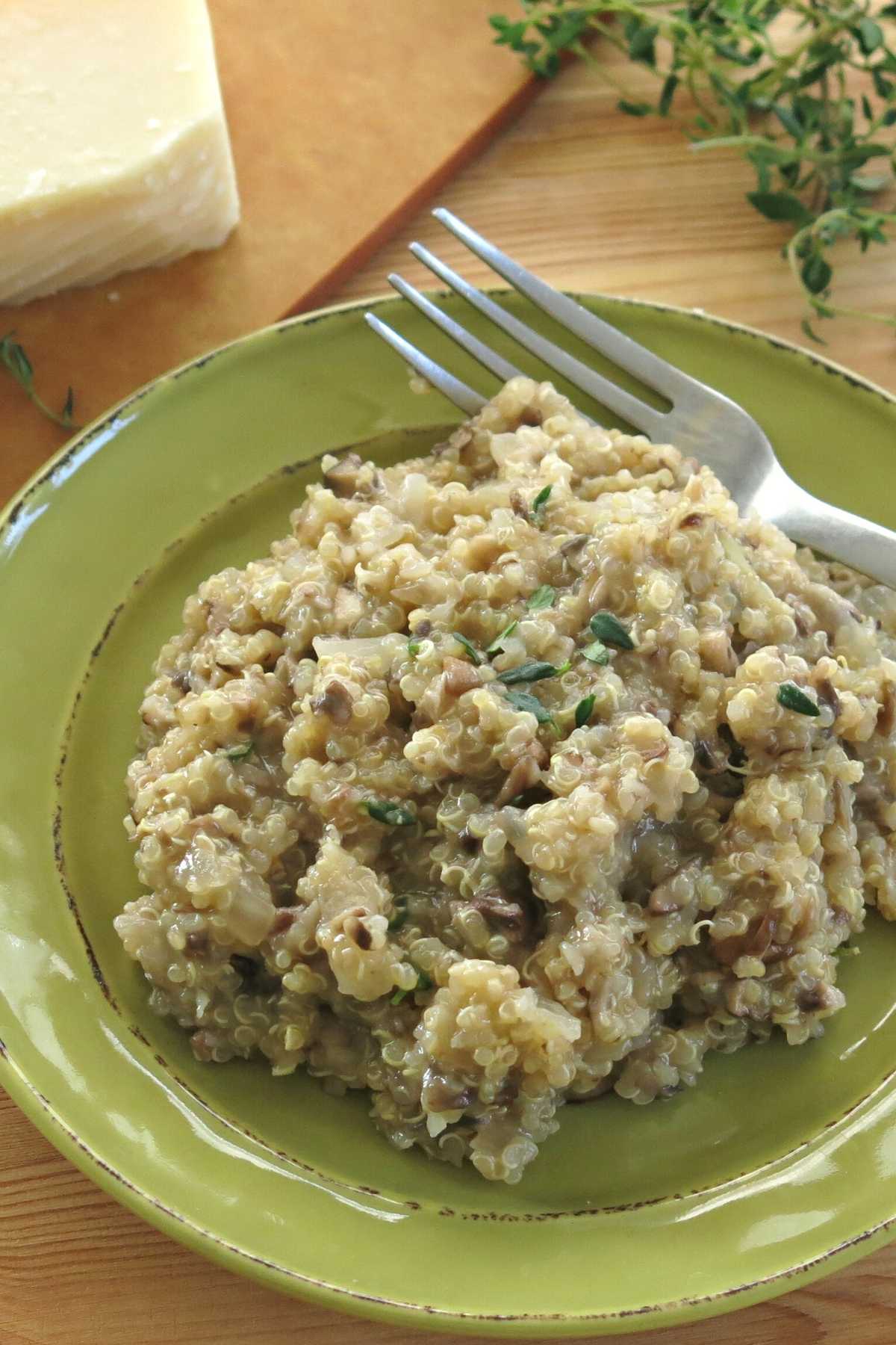 Plate with mushroom quinoa risotto with fresh thyme sprinkled on top.