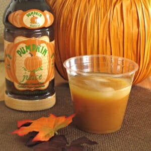 A cup of pumpkin juice next to a bottle of pumpkin juice from Universal's The Wizarding World of Harry Potter.