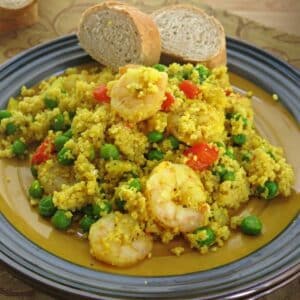 Shrimp couscous paella with peas and peppers on a plate.