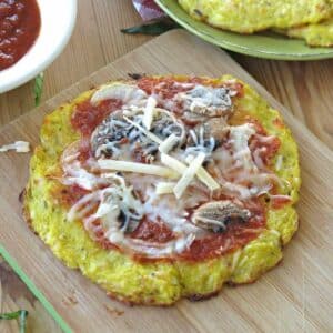 Spaghetti squash pizza crust cooked until crispy and topped with sauce, mushrooms, and cheese.