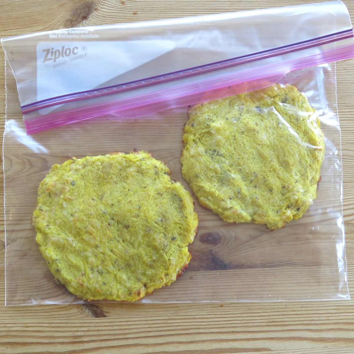 Two spaghetti squash pizza crusts in a sealed freezer bag.