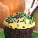 Chocolate Pumpkin Cupcake with Pumpkin Buttercream Frosting topped with sprinkles on a napkin.