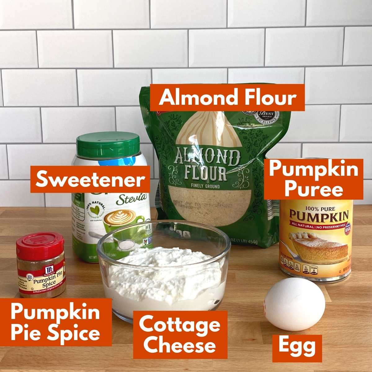 Collage of ingredients to make pumpkin chaffles: almond flour, pumpkin puree, cottage cheese, sweetener, pumpkin pie spice, and egg.