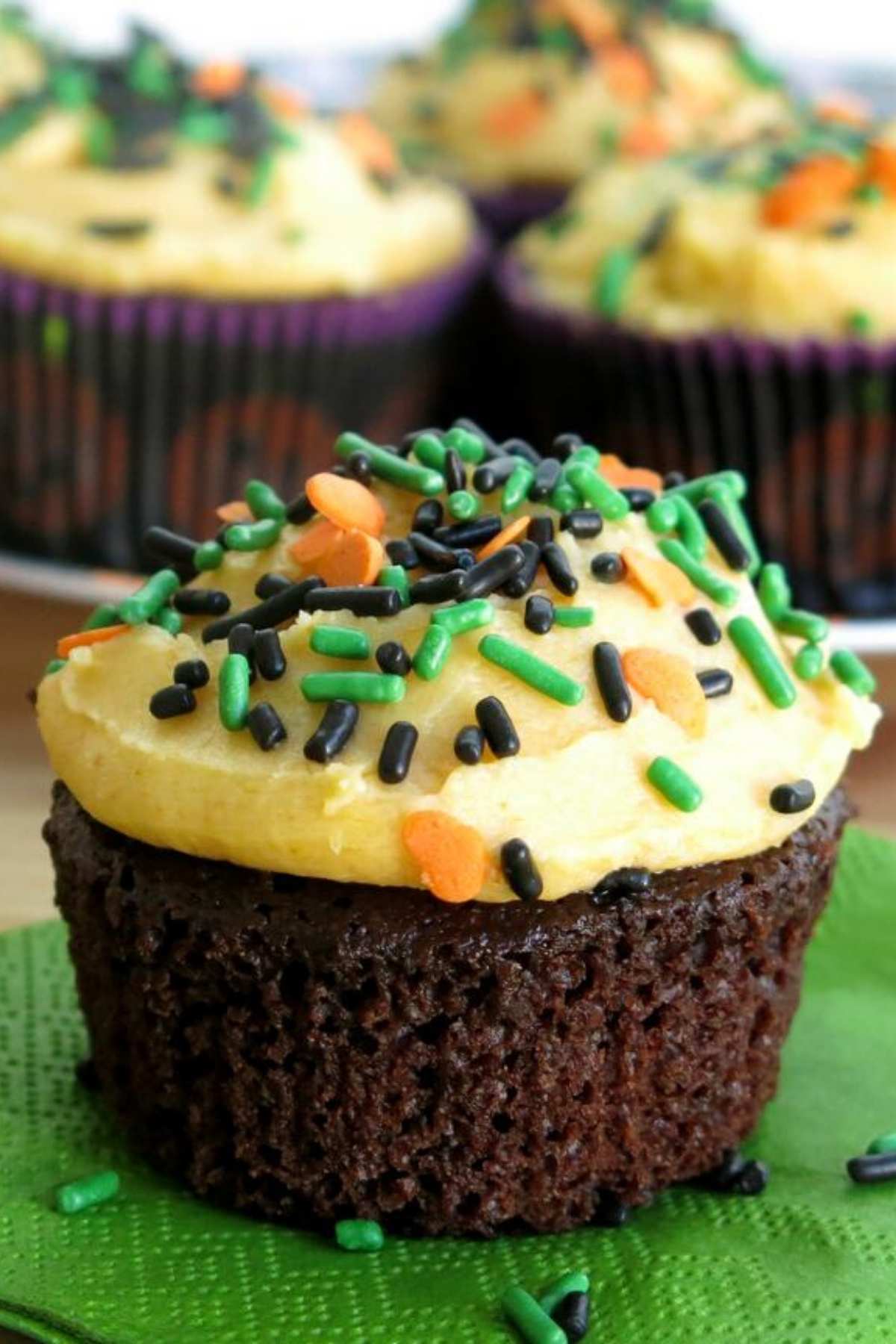 Chocolate Pumpkin Cupcakes with pumpkin buttercream frosting topped with sprinkles.