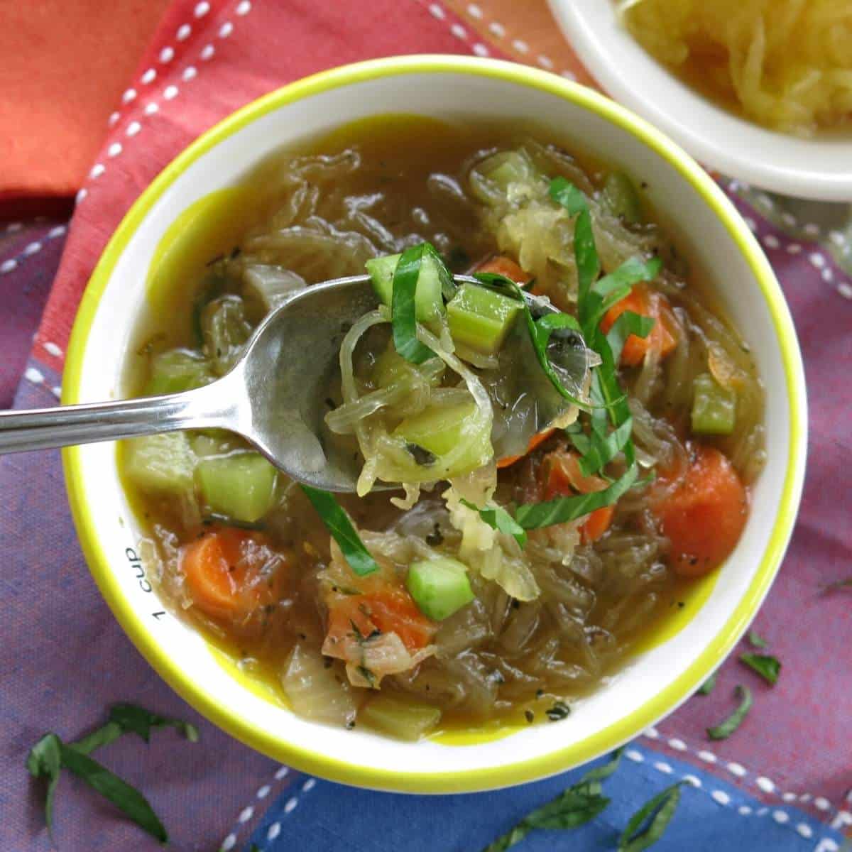 Spoon lifting up some spaghetti squash vegetable soup.