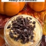Pumpkin cottage cheese dessert topped with chopped chocolate in a clear serving dish.