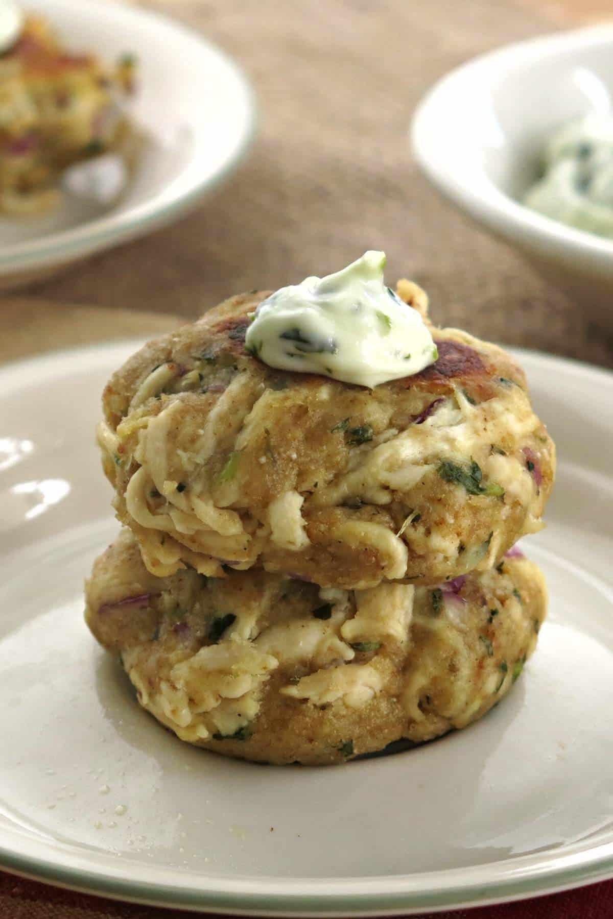 Two chicken cakes made with shredded chicken stacked on top of each other.