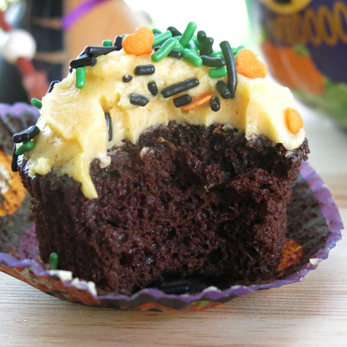 Wacky chocolate pumpkin cupcake with a bite removed to expose the moist inside cake.