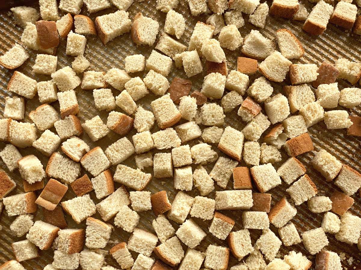 Bread cubes on a baking sheet.