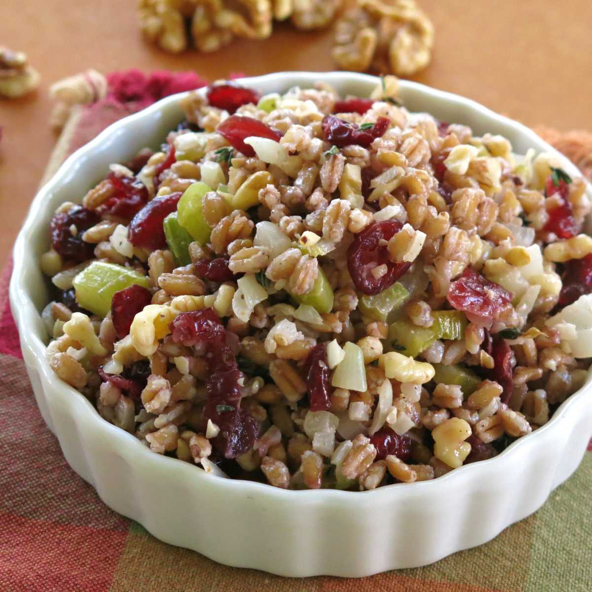 Farro stuffing with cranberries, walnuts, onion, and celery in a serving bowl.