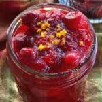 Low-sugar cranberry sauce garnished with orange zest in a mason jar.