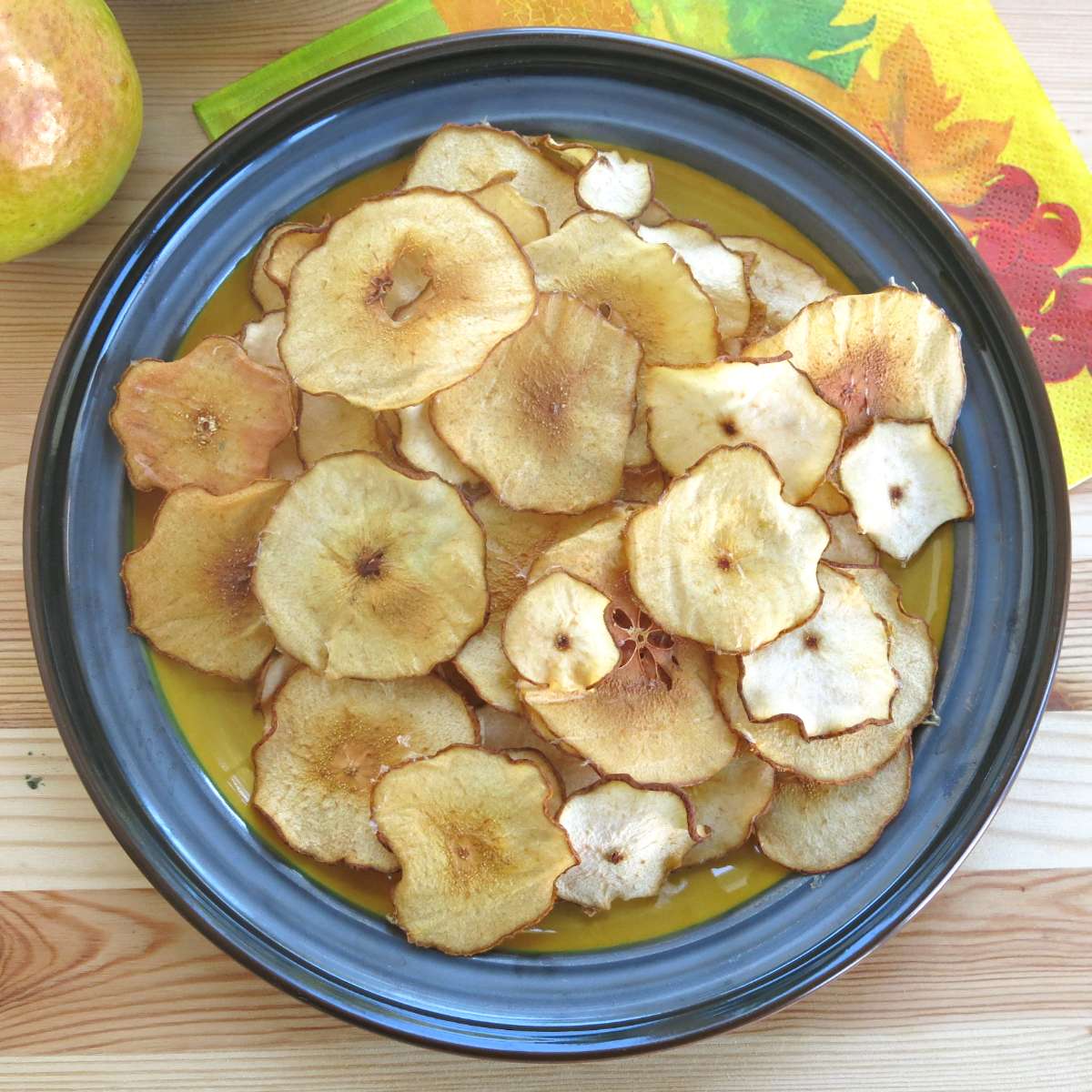 Baked pear chips piled on a plate.