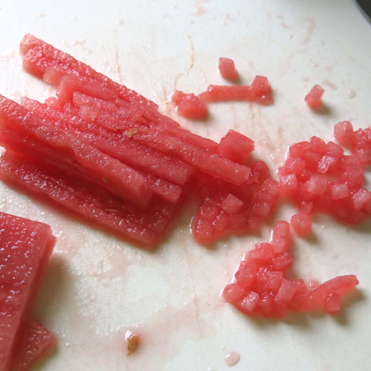 Long skinny rectangular pieces of watermelon partially diced.