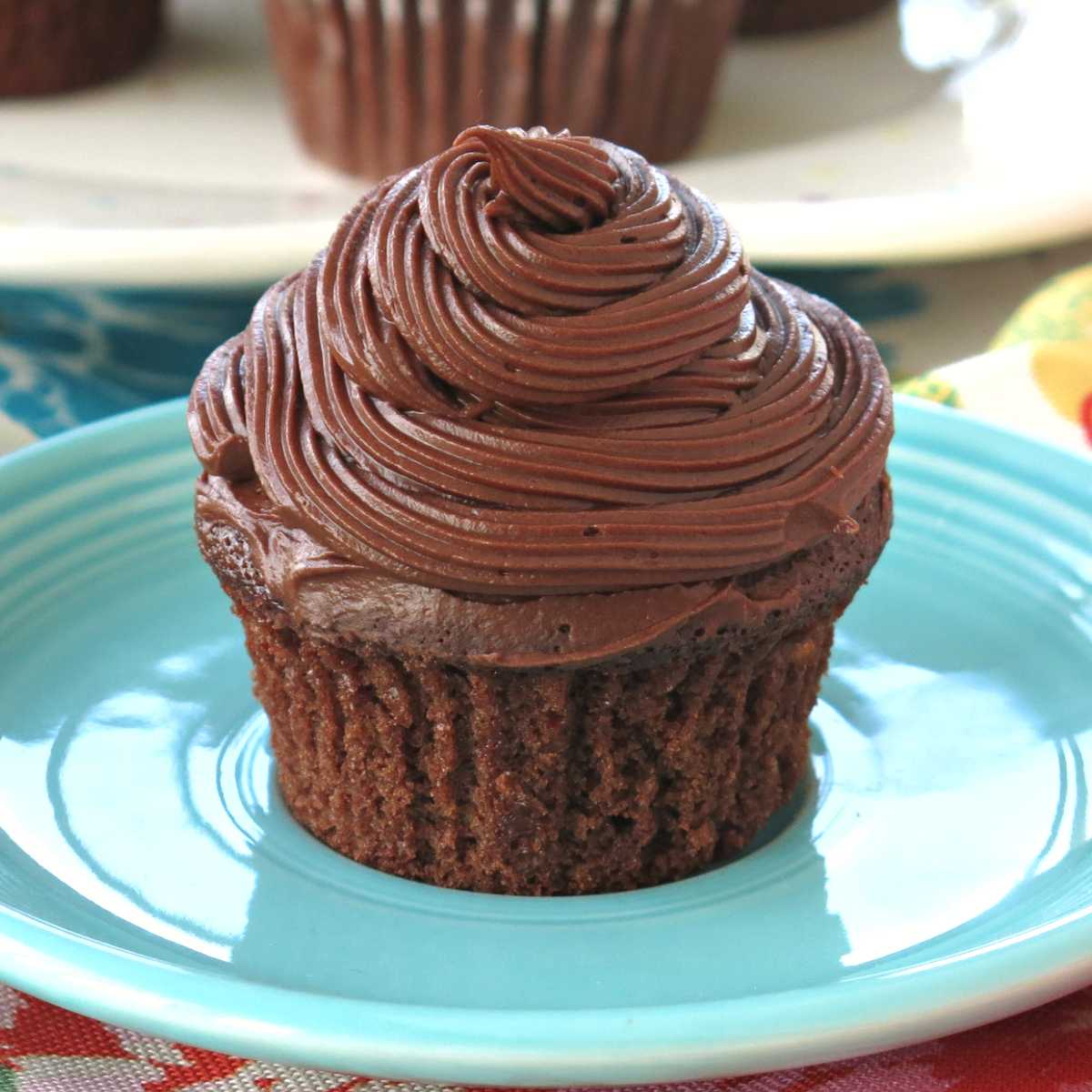 Eggless chocolate cupcake with dairy-free chocolate frosting on a plate.