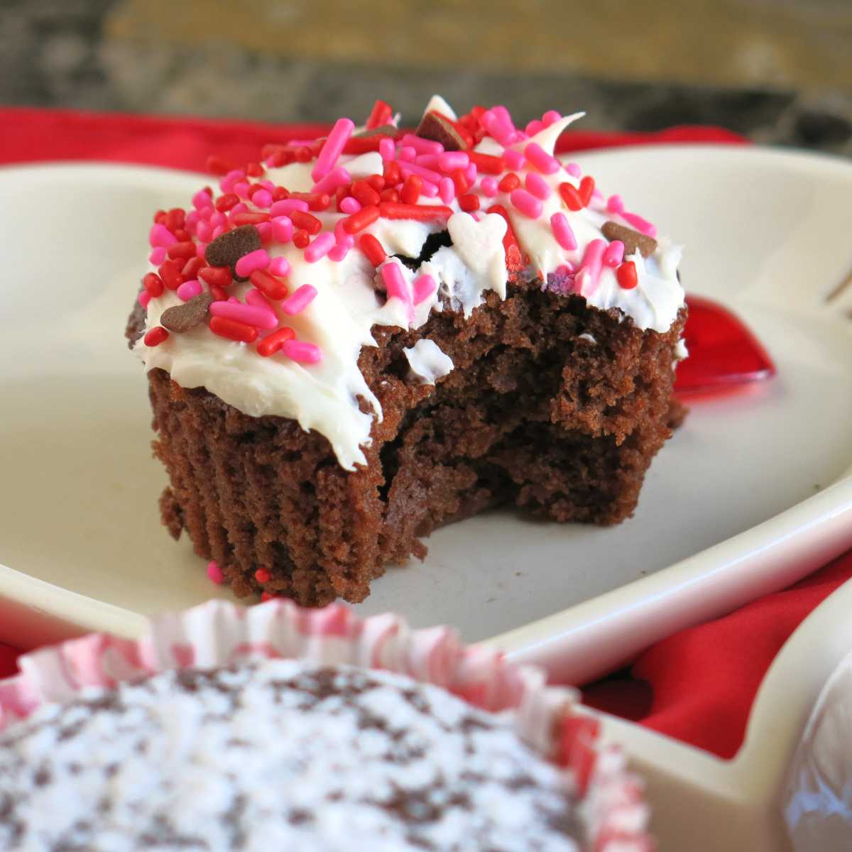 Vegan chocolate cupcake with bite taken out of it.