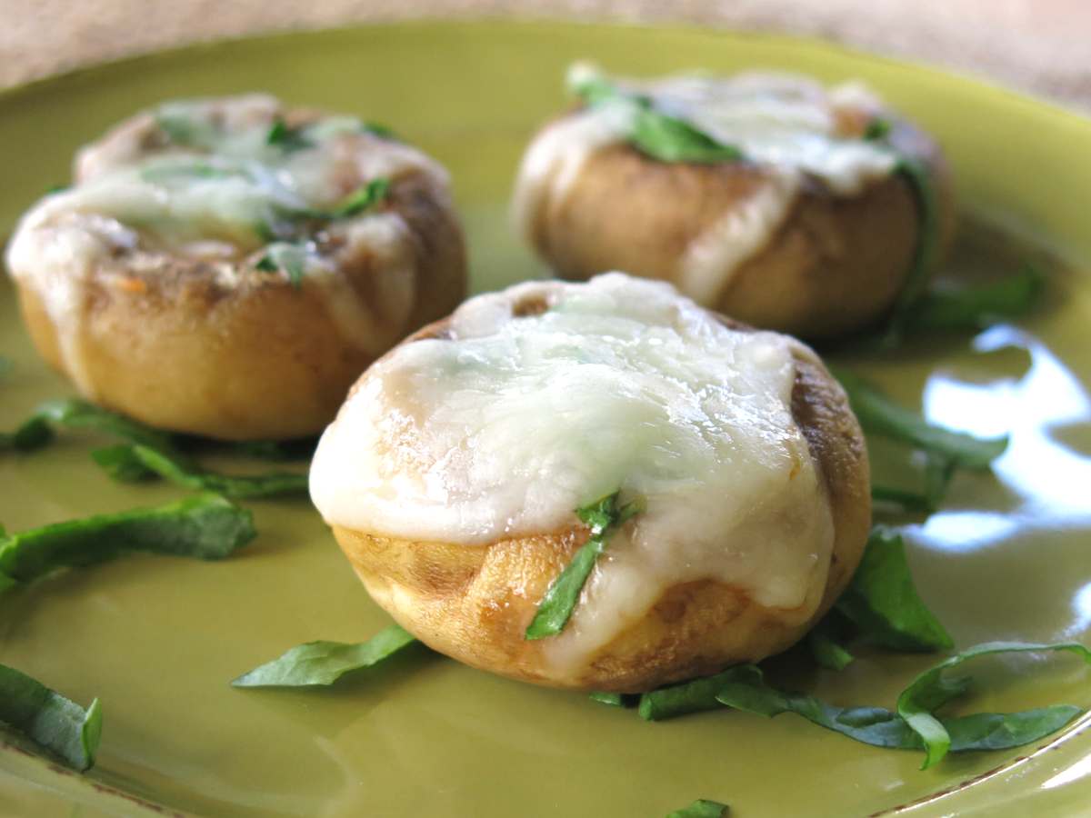 Three low-carb pizza stuffed mushrooms on a plate