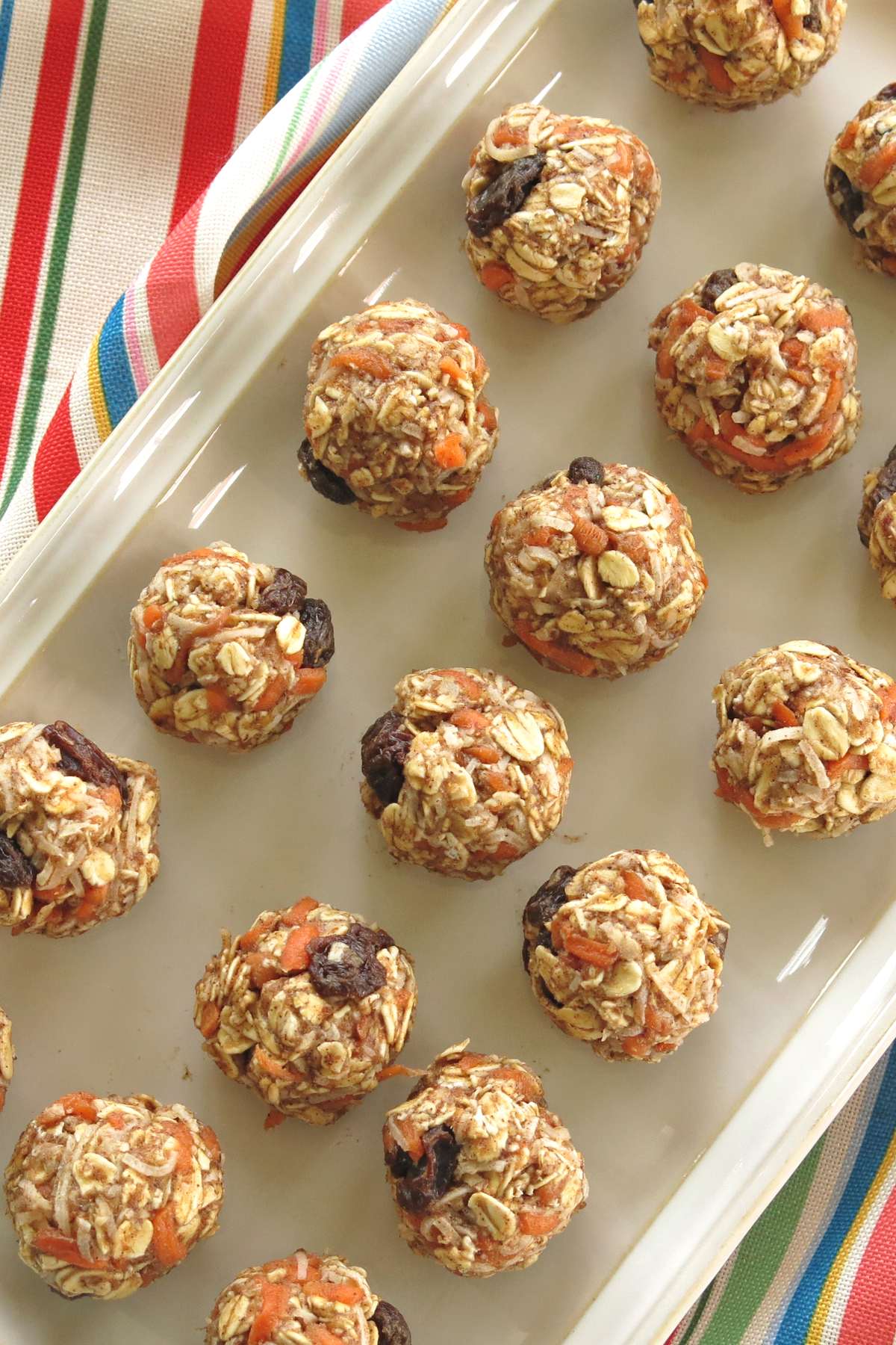 No-Bake Carrot Cake Energy Bites in 3 rows on a rectangle plate.