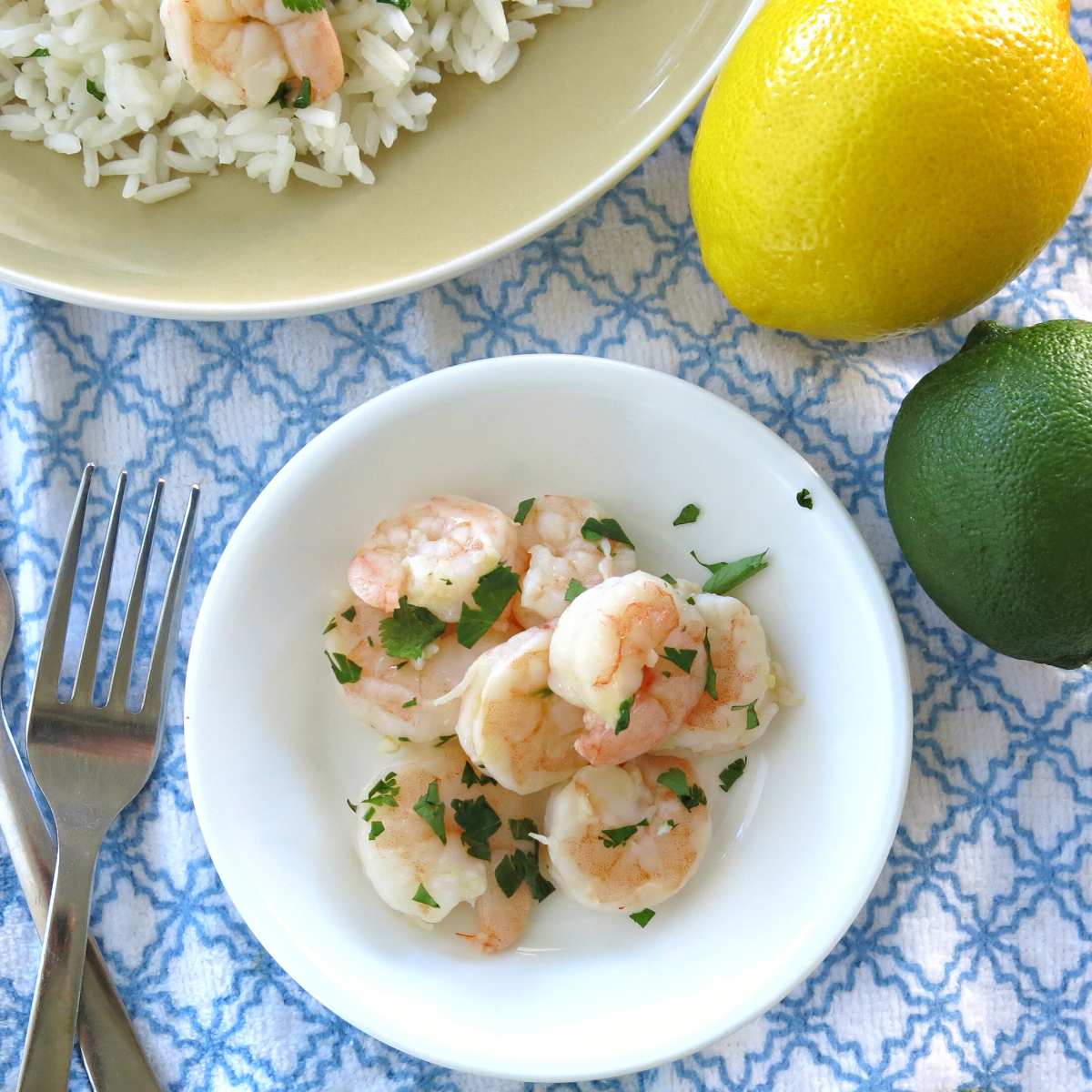 Chilled cilantro lime shrimp on a plate with forks next to it.