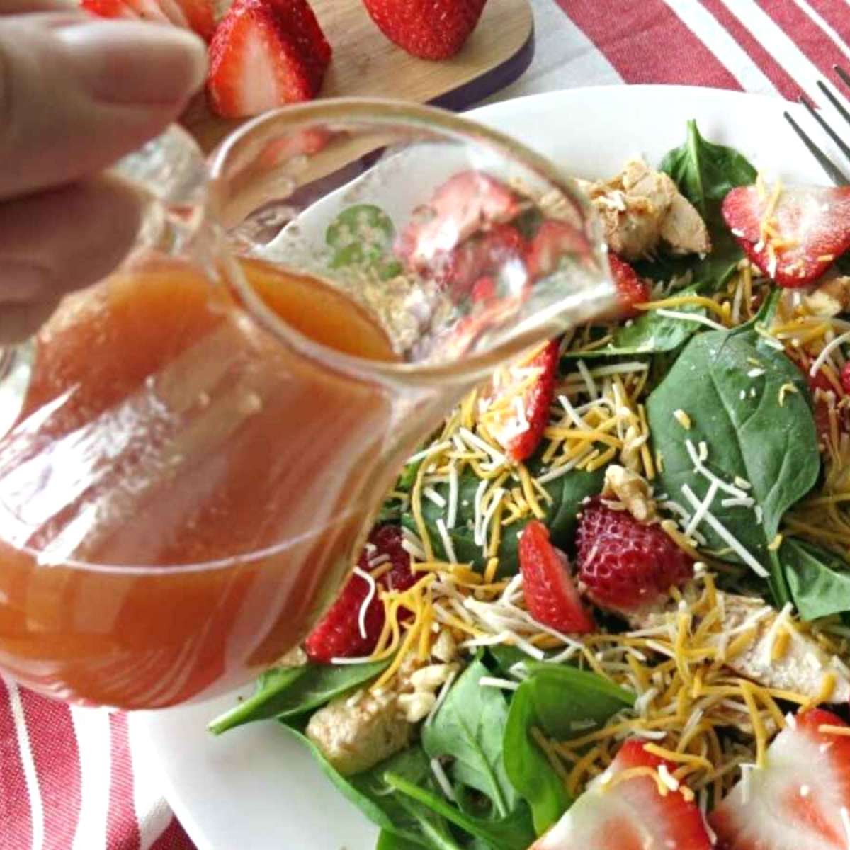 Red wine vinegar dressing being poured over a fresh green salad.