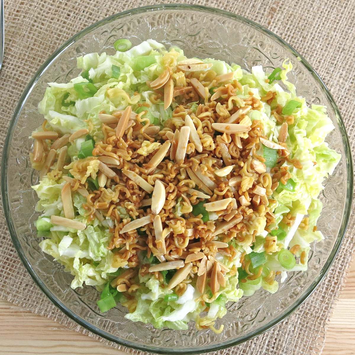 Ramen noodle cabbage salad in a glass salad bowl.