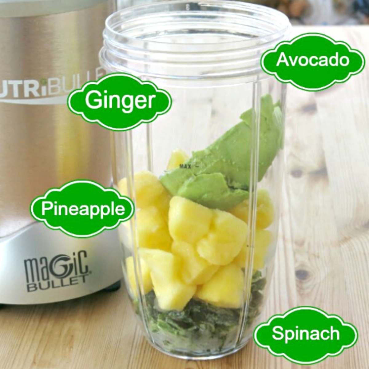 Ingredients in a Nutribullet cup: Pineapple, avocado, spinach, and ginger.