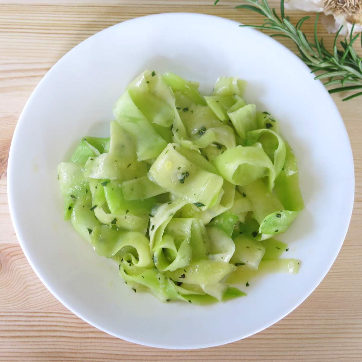 Sauteed zucchini ribbons on a plate.