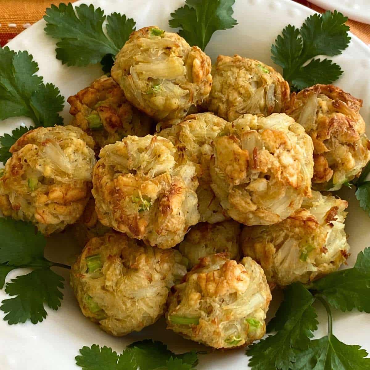 Baked crab balls piled in a white bowl.