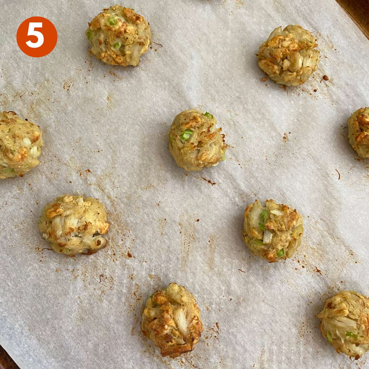 Baked crab balls on a cookie sheet.