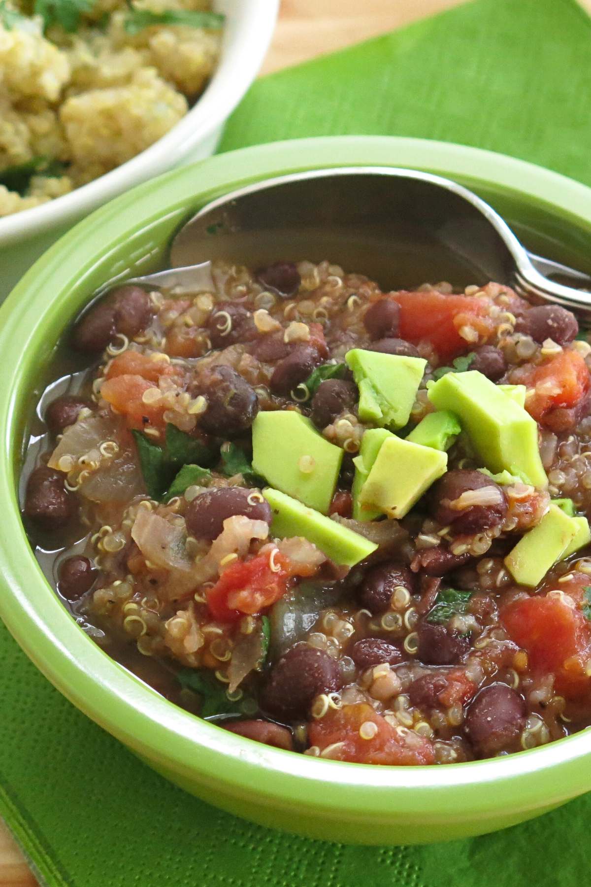 Black bean quinoa soup in a bowl with a spoon.