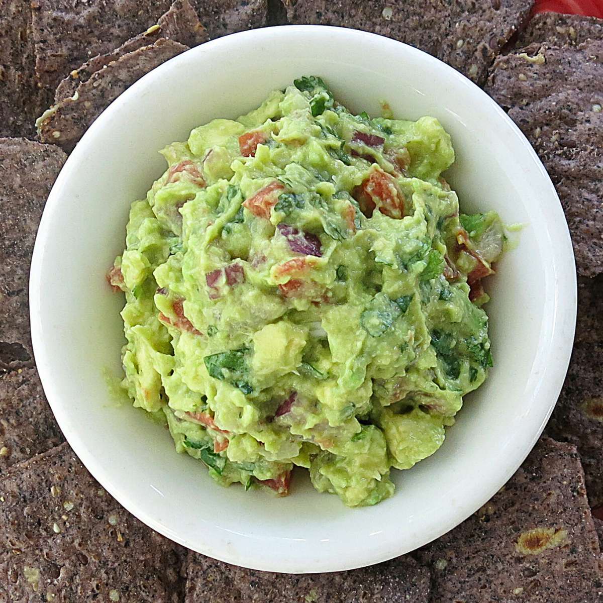 4-Ingredient guacamole in a bowl surrounded by chips.