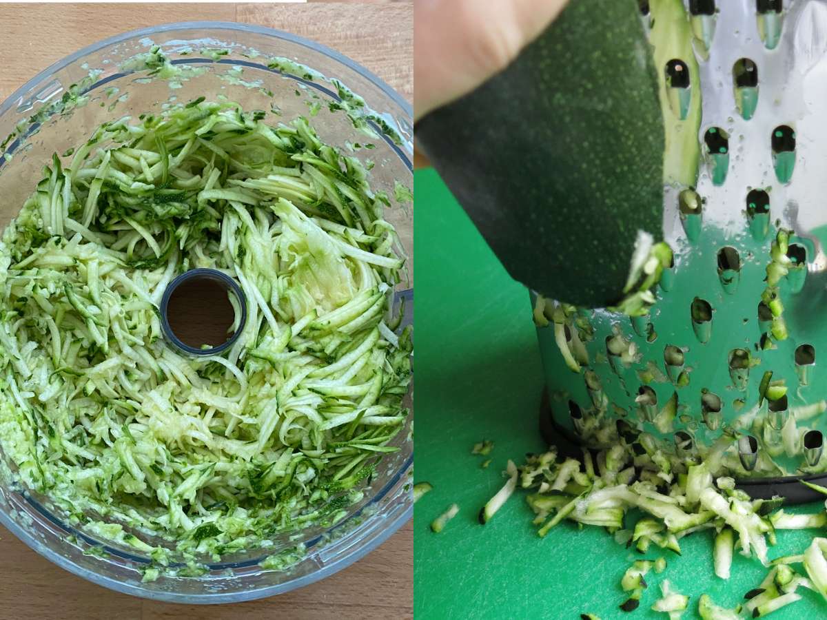 Zucchini shredded in the bowl of a food processor and and hand holding a zucchini and pressing agains a box grater.