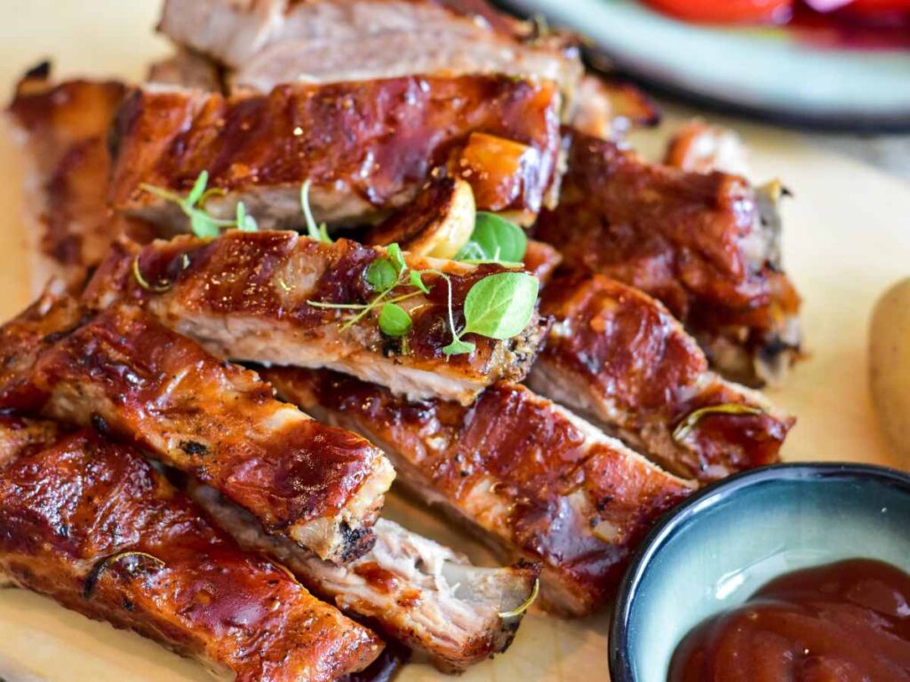 Ribs stacked on a plate.