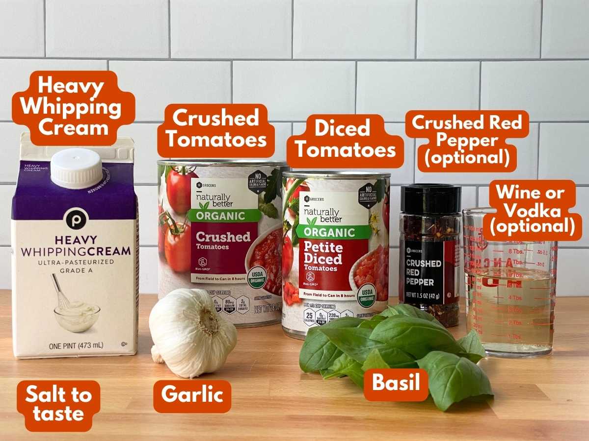 Labeled ingredients to make lobster ravioli sauce: crushed tomatoes, diced tomatoes, heavy whipping cream, garlic, basil, and  optional wine and crushed red pepper/