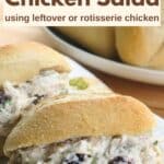 Shredded chicken salad made with leftover chicken in an oblong roll with more of the same behind it.