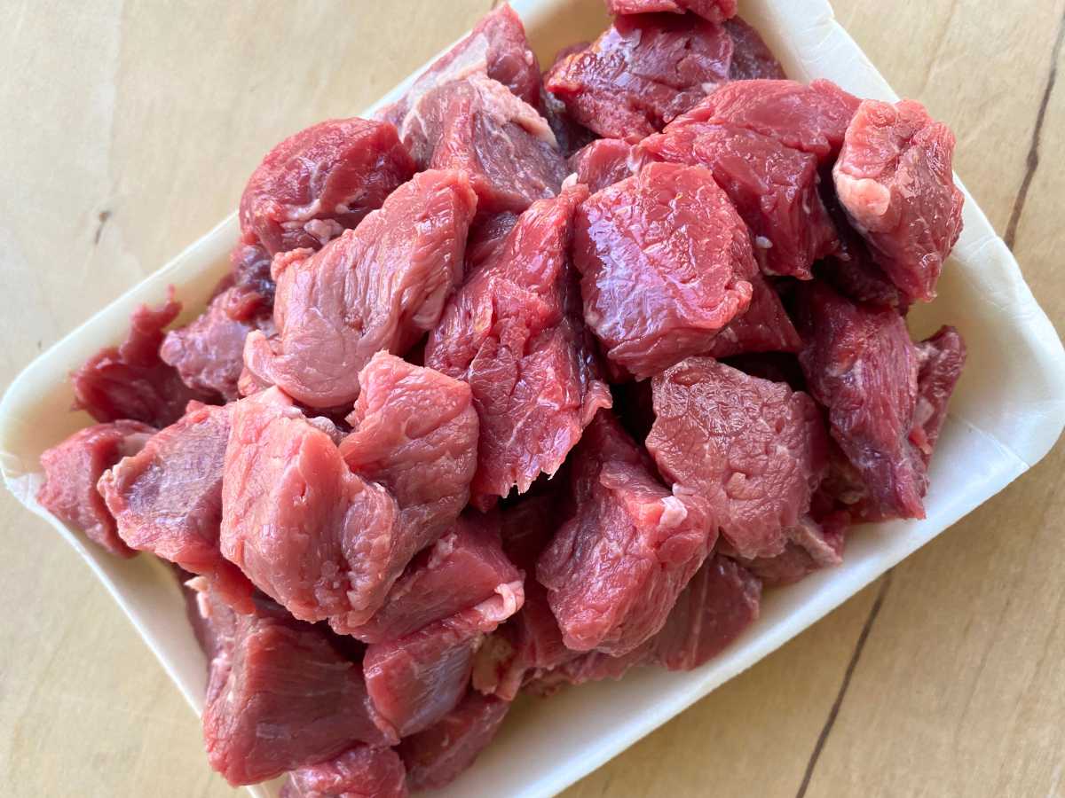 Cubes of beef chuck roast on a cutting board.