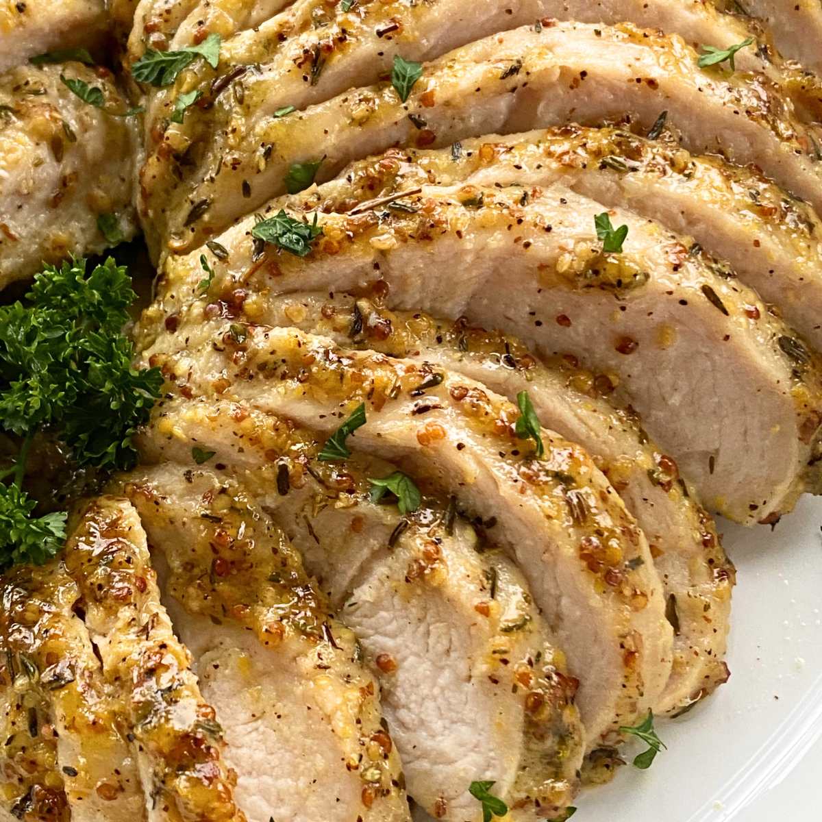 Slices of turkey tenderloin that have been marinated in a mixture of maple syrup, olive oil, stone ground dijon mustard, dried thyme leaves, salt, and pepper.